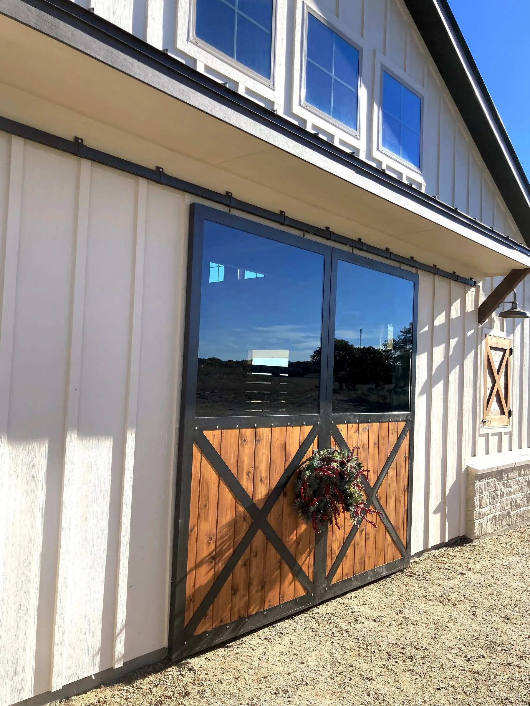 Board-and-batten barn with black-framed windows.