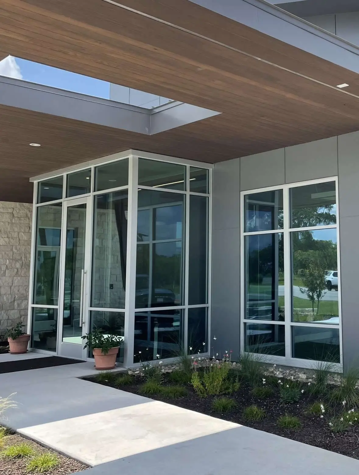 Commercial glass entry with white-framed windows in Central Texas.