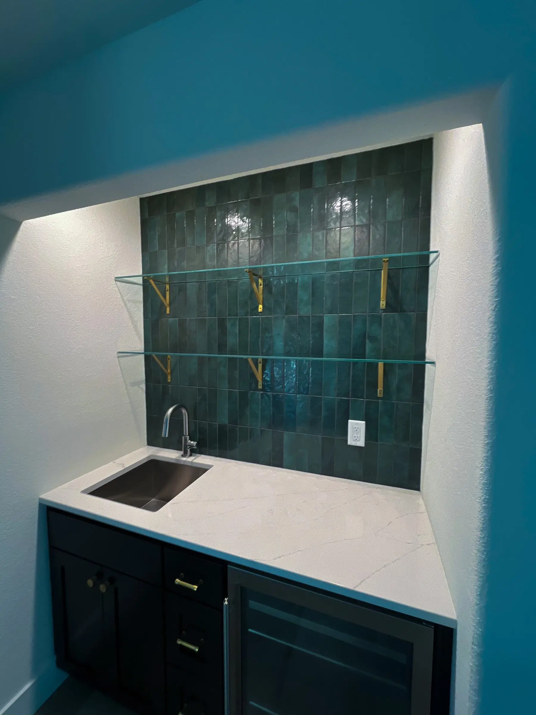 Floating glass shelves on a wet bar in a Central Texas home.