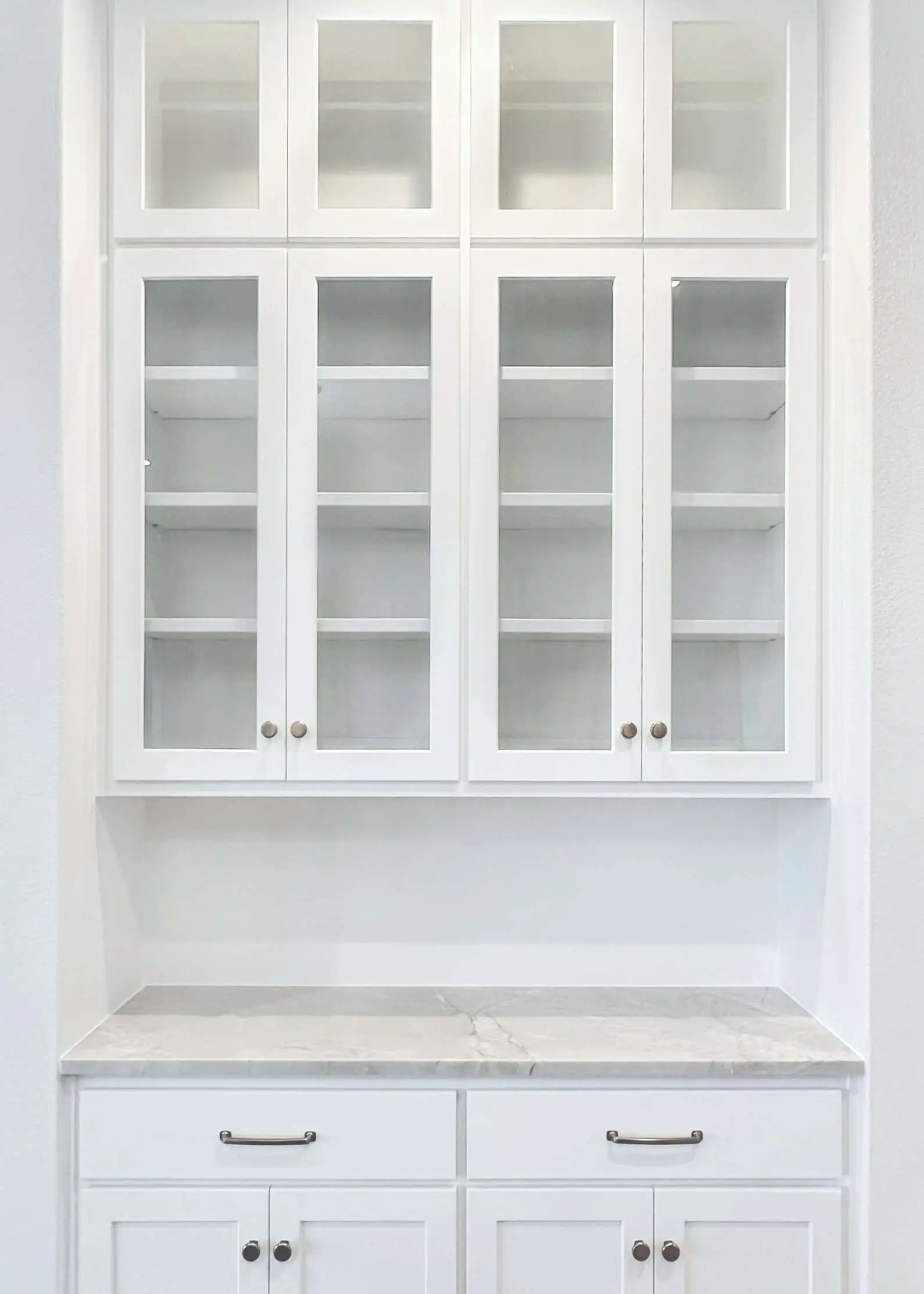 Built-in hutch with glass-front cabinet doors in a Central Texas home.