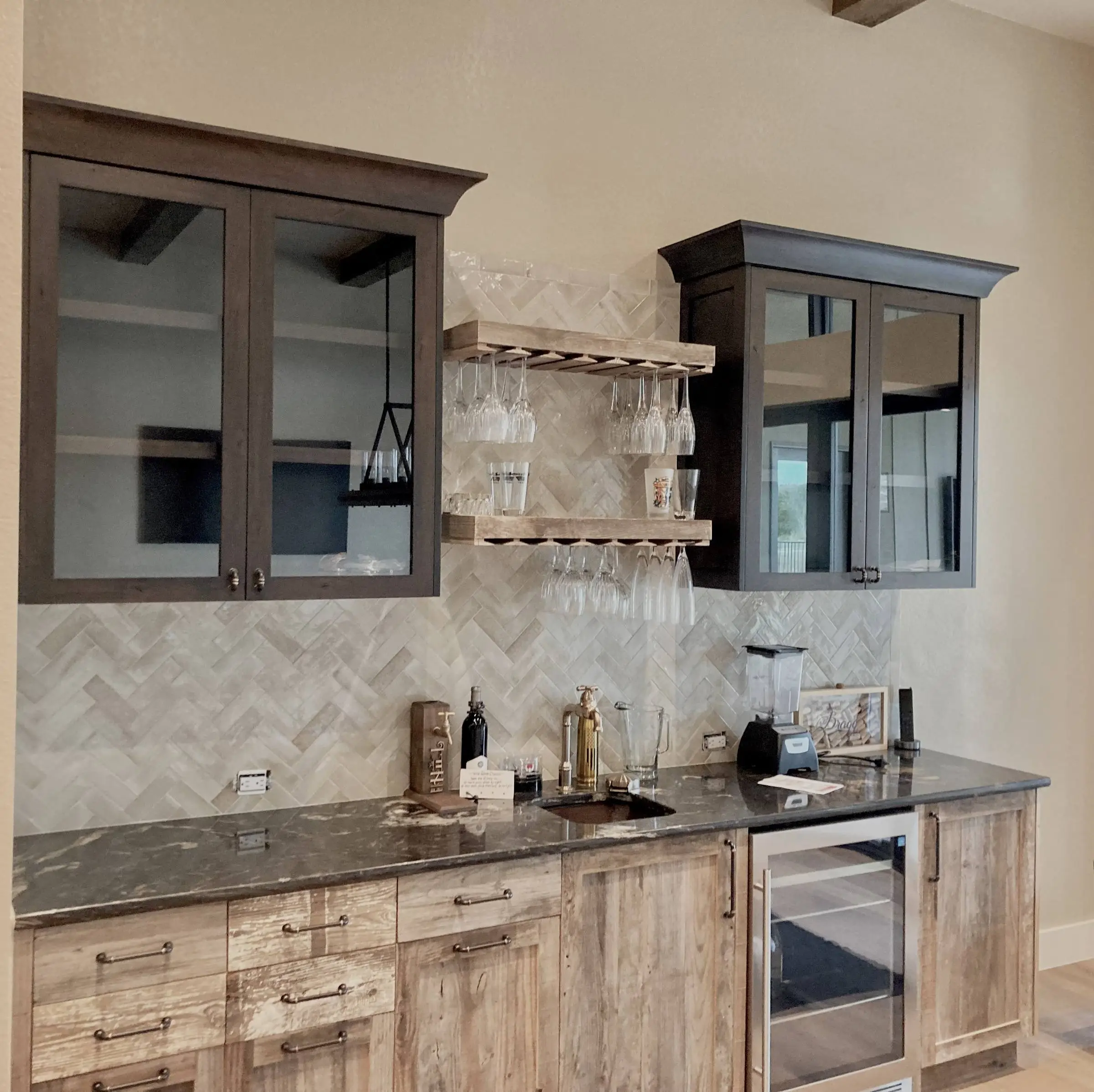 Wet bar with glass-front upper cabinets and glass shelves in a Central Texas home.
